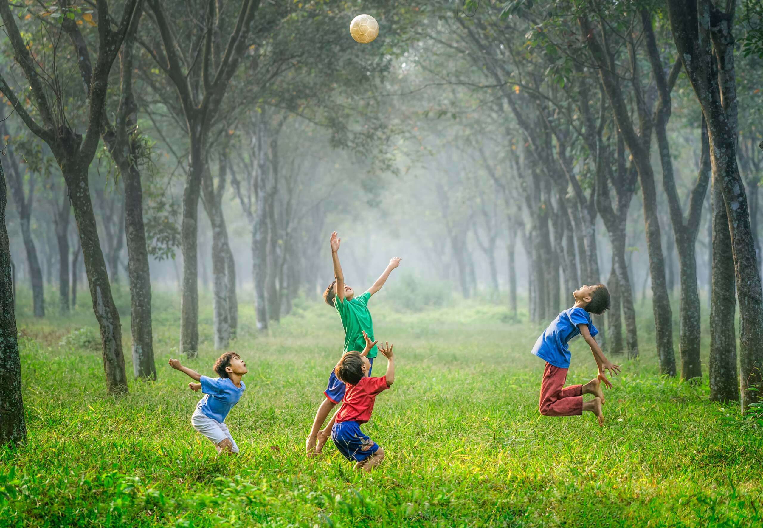 Niños jugando y saltando con una pelota