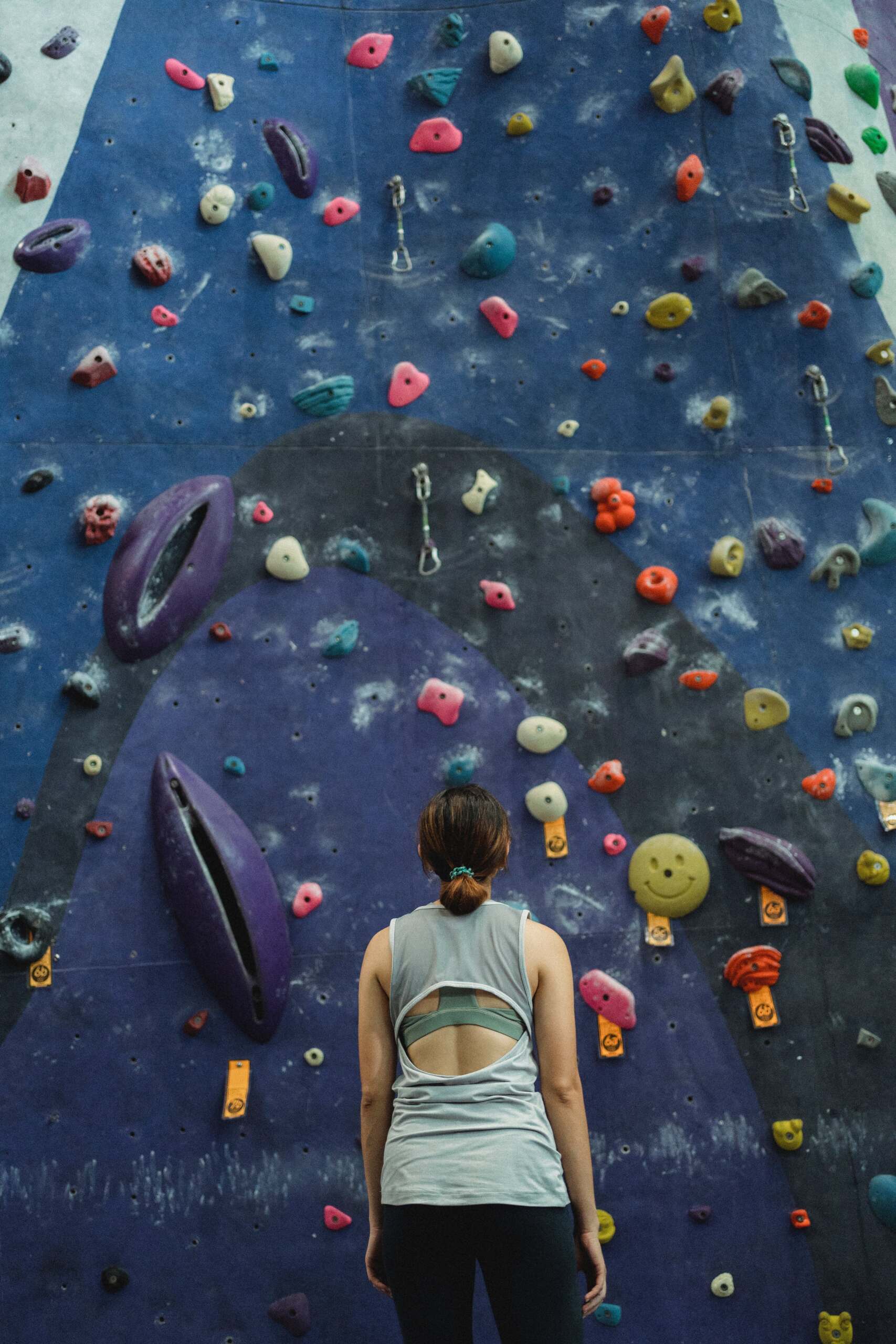 Mujer frente a pared de escalada