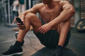 Hombre en gimnasio escuchando música